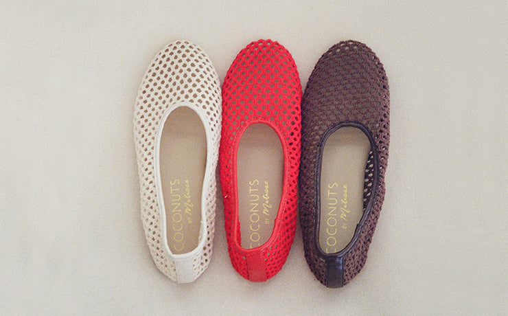 Three pairs of women's flats in white, red, and brown on a light gray background.