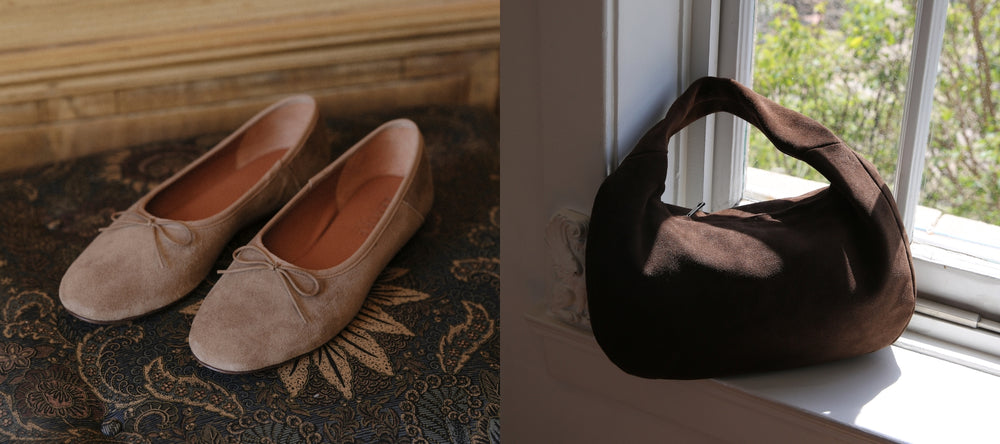 Pair of beige suede shoes on a textured surface next to a brown suede handbag on a windowsill.