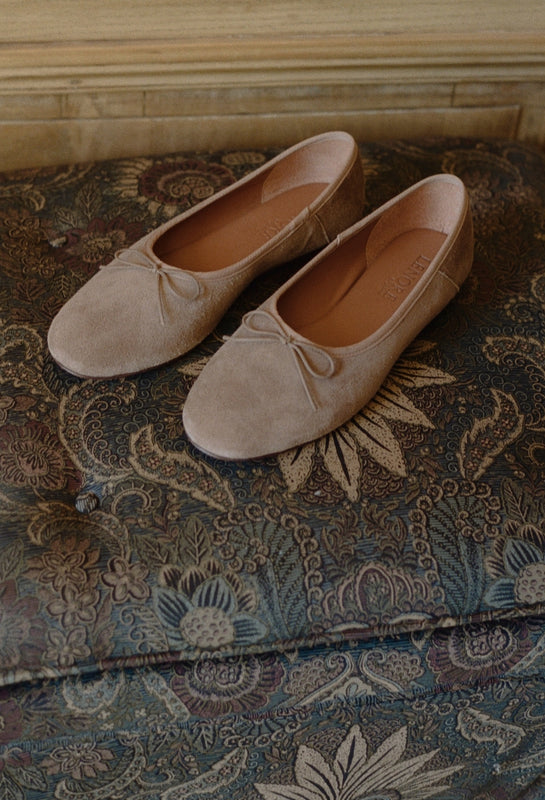 Pair of beige loafers on a patterned fabric surface