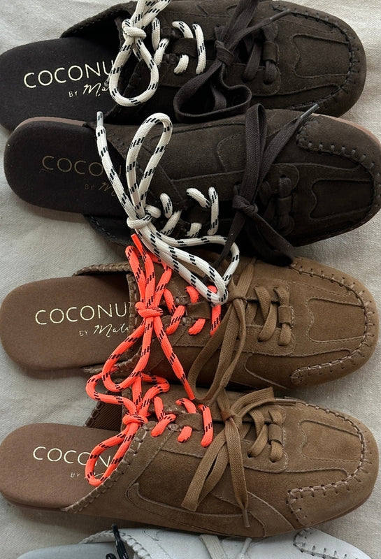 Brown suede shoes with colorful laces on a light background
