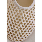 Close-up of a beige woven flat with a plain background.