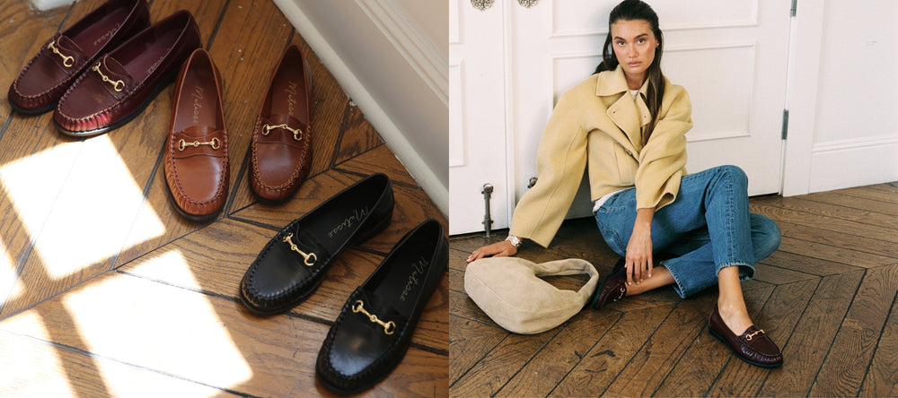 Pair of brown loafers on a wooden floor with a person wearing a beige coat and blue jeans sitting on the floor.