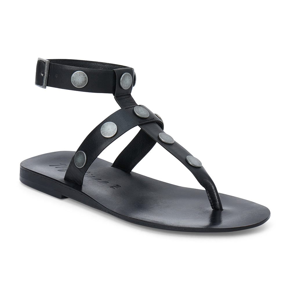Black strappy thong sandal with metal studs and ankle buckle shown on a white background.