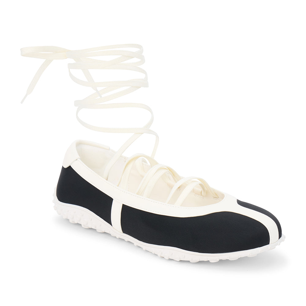 Black vegan sneaker-ballet flat hybrid with contrast trim and wraparound ankle laces, shown on a white background.