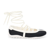 Black vegan sneaker-ballet flat hybrid with contrast trim and wraparound ankle laces, shown on a white background.