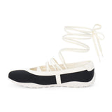 Black vegan sneaker-ballet flat hybrid with contrast trim and wraparound ankle laces, shown on a white background.