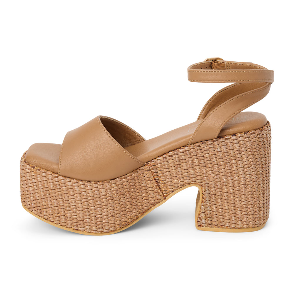 Cognac faux leather platform sandal with wide front strap, adjustable ankle strap, chunky woven platform heel, and open toe, shown on a white background.