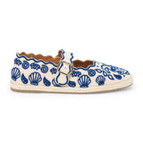 Blue embroidered canvas flat with scalloped edges and buckle strap shown on a white background.