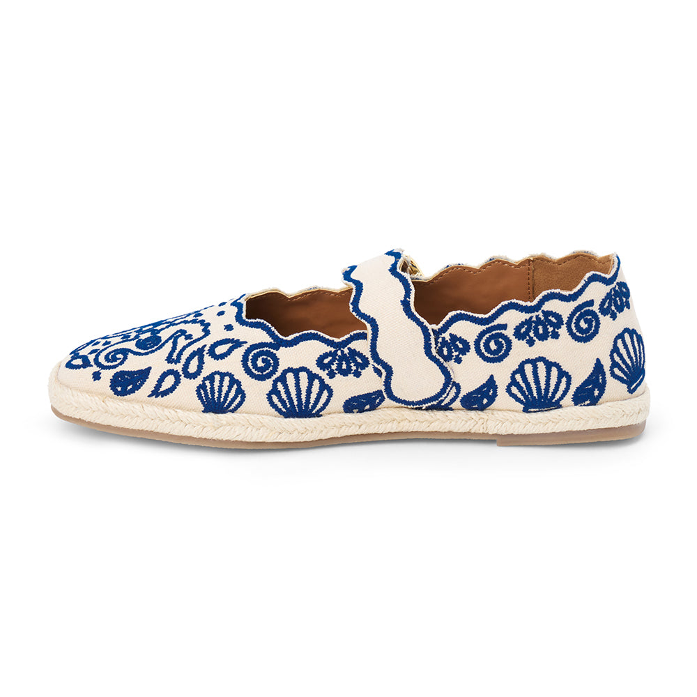 Blue embroidered canvas flat with scalloped edges and buckle strap shown on a white background.