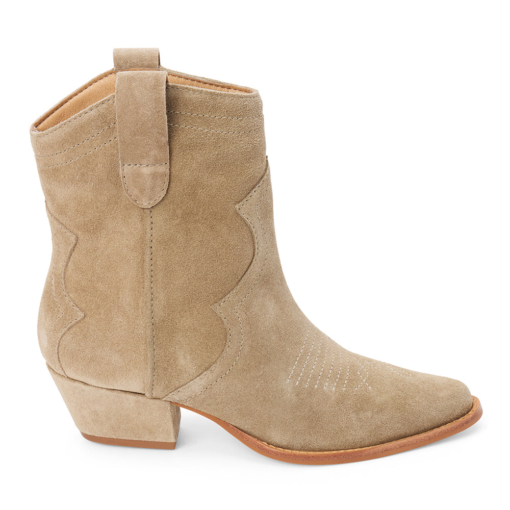 Taupe suede ankle boot with western stitching, a pointed toe, stacked heel, and pull tab, shown in side profile on a white background.