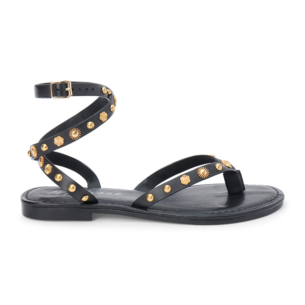 Black leather thong sandal with gold studs and wraparound ankle strap shown on a white background.