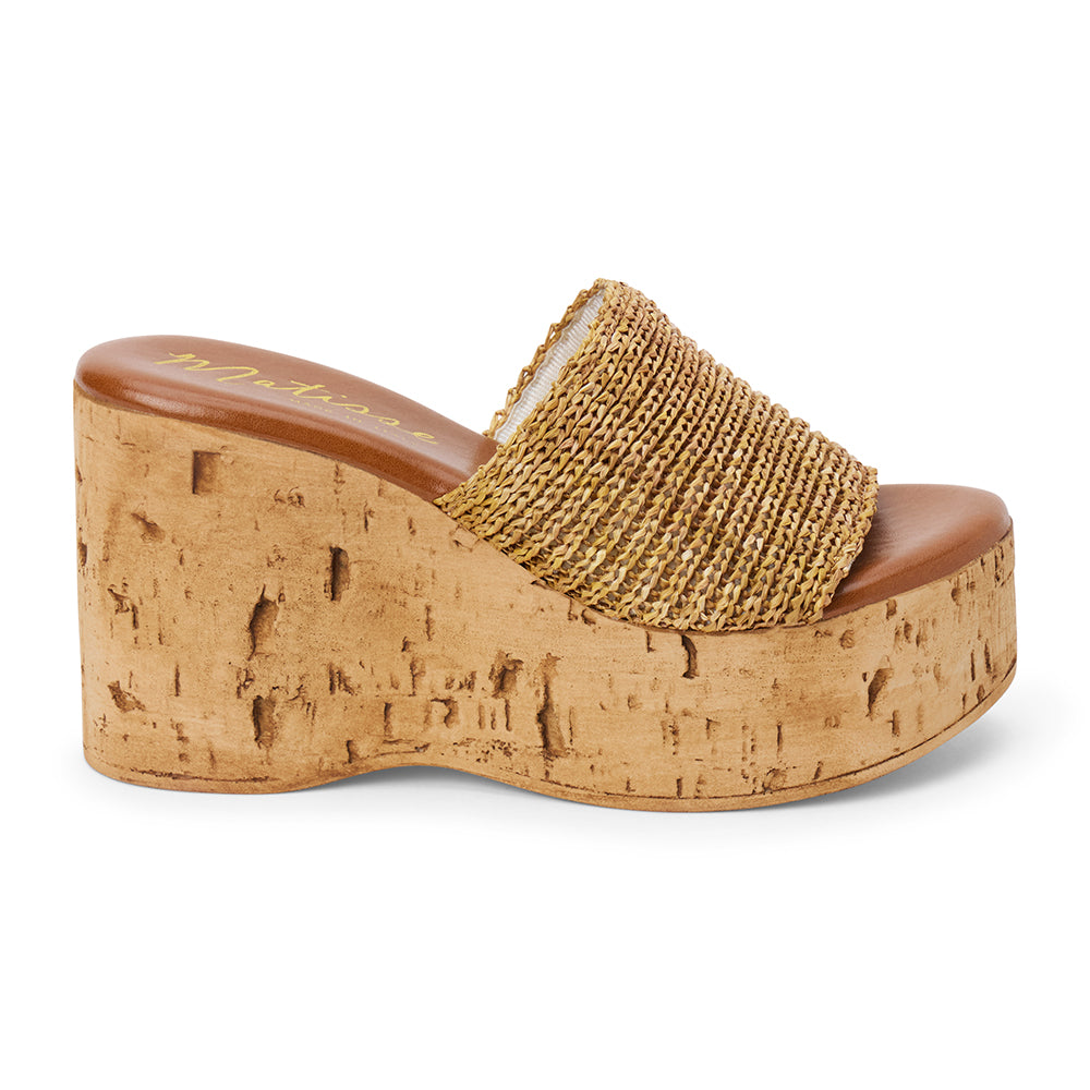 Tan raffia platform sandal with cork wedge and wide strap shown on a white background.