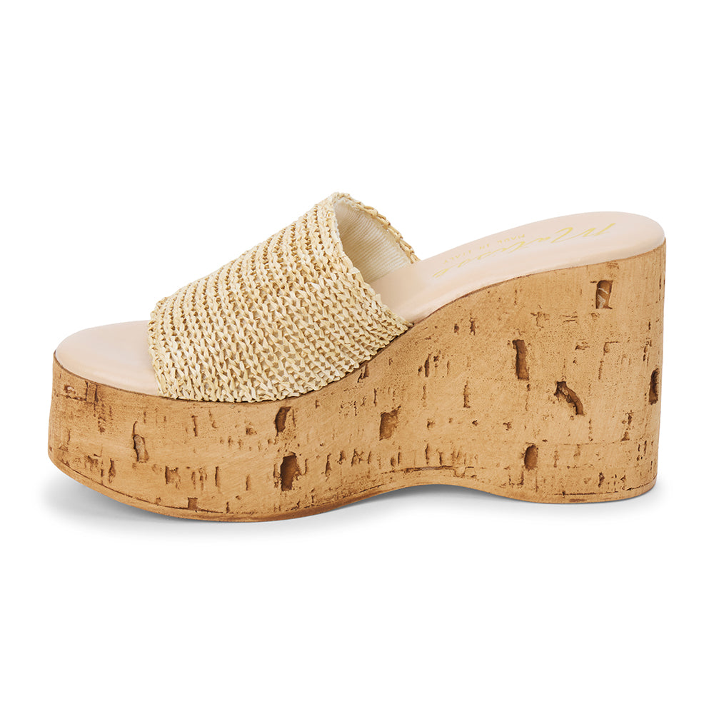 Ivory raffia platform sandal with cork wedge and wide strap shown on a white background.