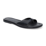 Black leather flat sandal with minimalist thong strap and padded footbed, shown on a white background.