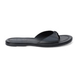 Black leather flat sandal with minimalist thong strap and padded footbed, shown on a white background.