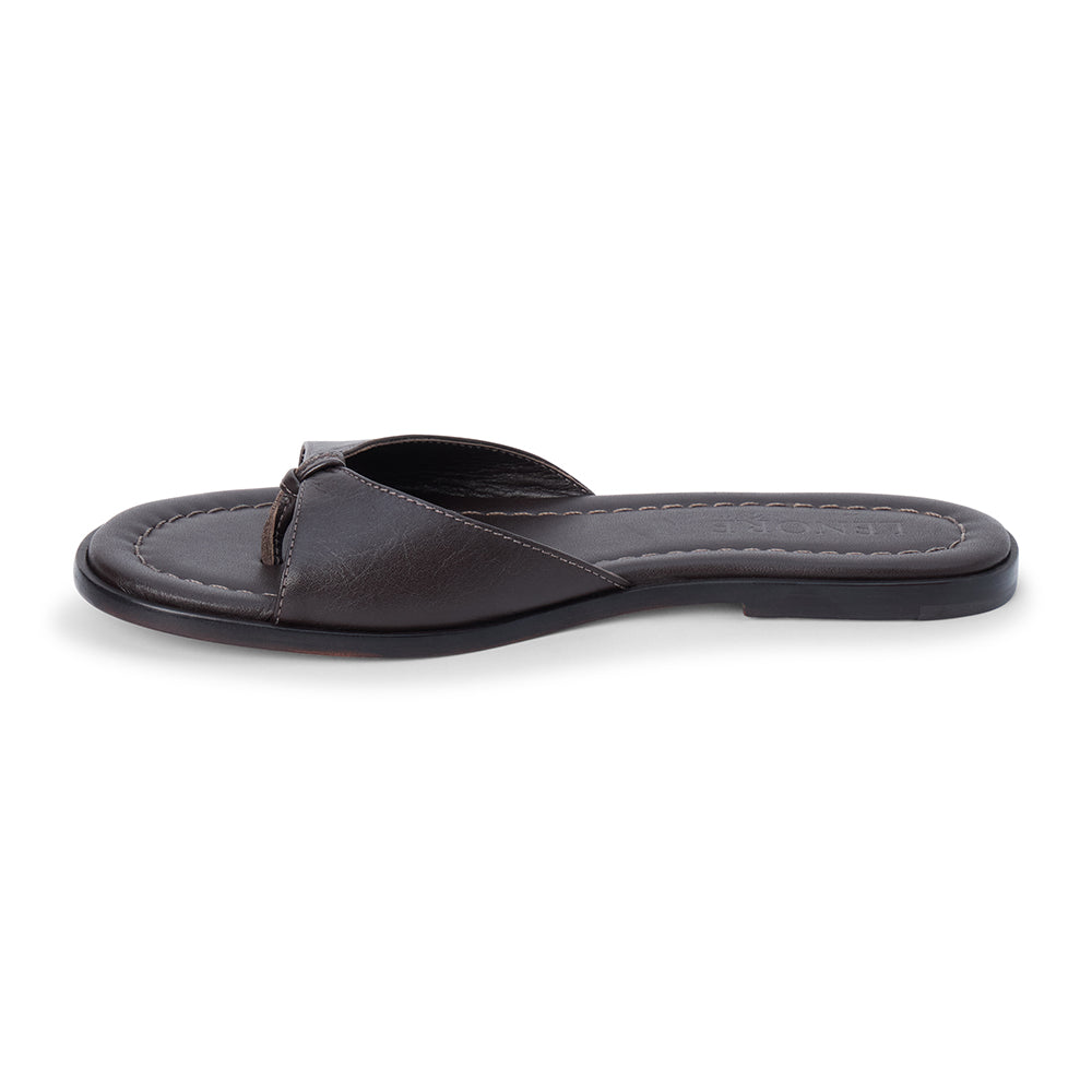 Chocolate brown leather slide sandal with minimalist thong strap and padded footbed, shown on a white background.