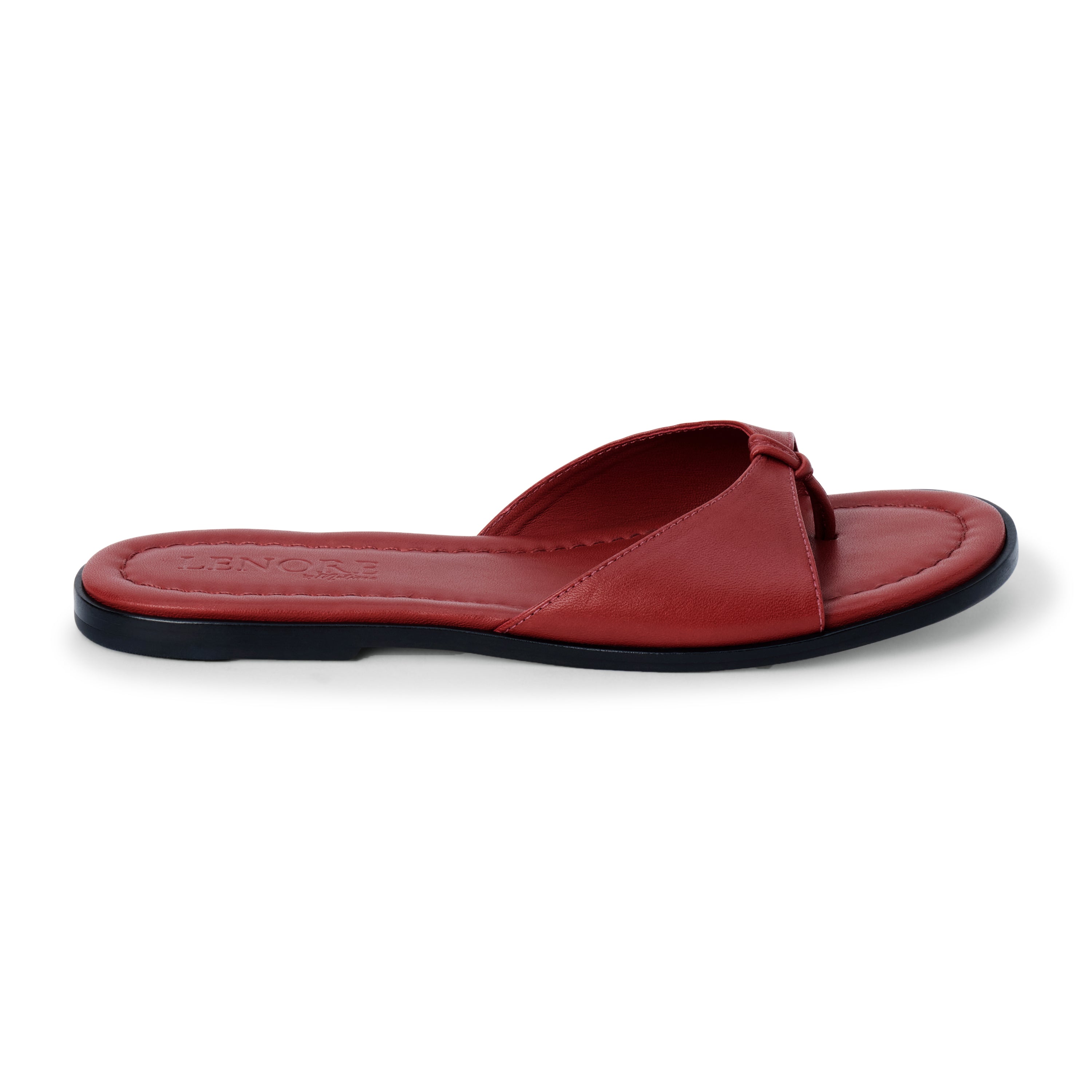 Cherry red leather flat sandal with minimalist thong strap and padded footbed, shown on a white background.