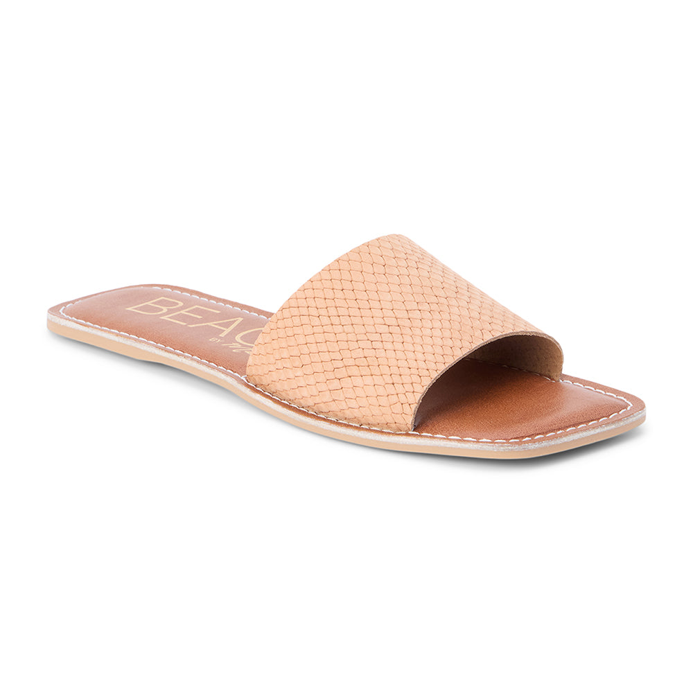 Pink suede slide sandal with a wide single strap and flat sole, shown on a white background.