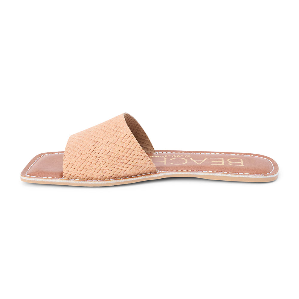 Pink suede slide sandal with a wide single strap and flat sole, shown on a white background.