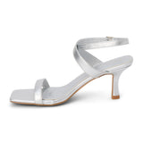 Silver faux leather heeled sandal with slim ankle strap, open square toe, mid-height heel, and buckle closure, shown on a white background.