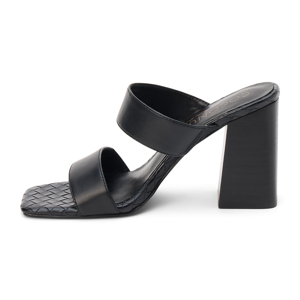 Black faux leather heeled sandal with wide straps, woven footbed, and tall block heel, shown on a white background.