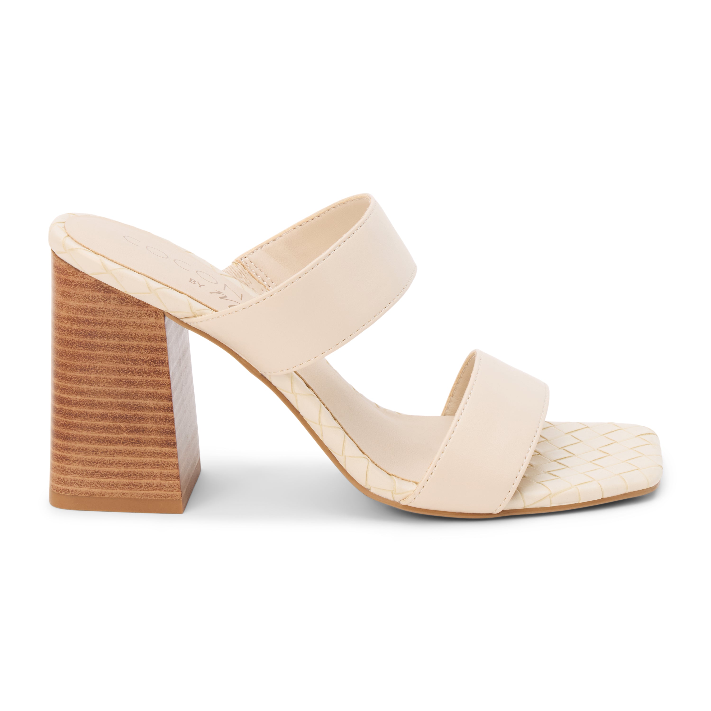 Beige faux leather heeled sandal with wide straps, woven footbed, and tall block heel, shown on a white background.