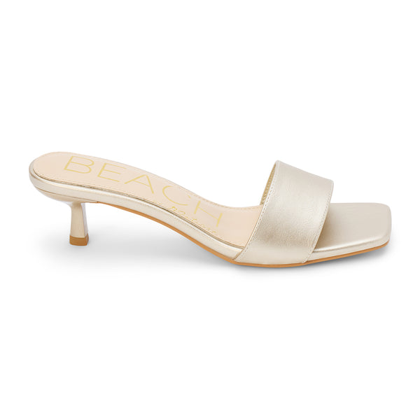 A sleek and modern essential, these gold kitten heel mules feature a minimalist square toe, soft metallic upper, and a comfortable low heel. Effortlessly refined for any occasion.