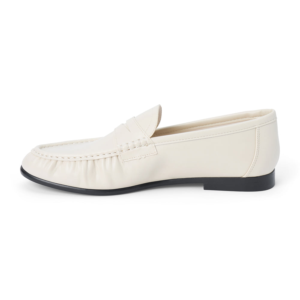 Vegan ivory faux leather penny loafer with a penny strap, moc-toe stitching, gathered toe detail, and black low heel shown on a white background.