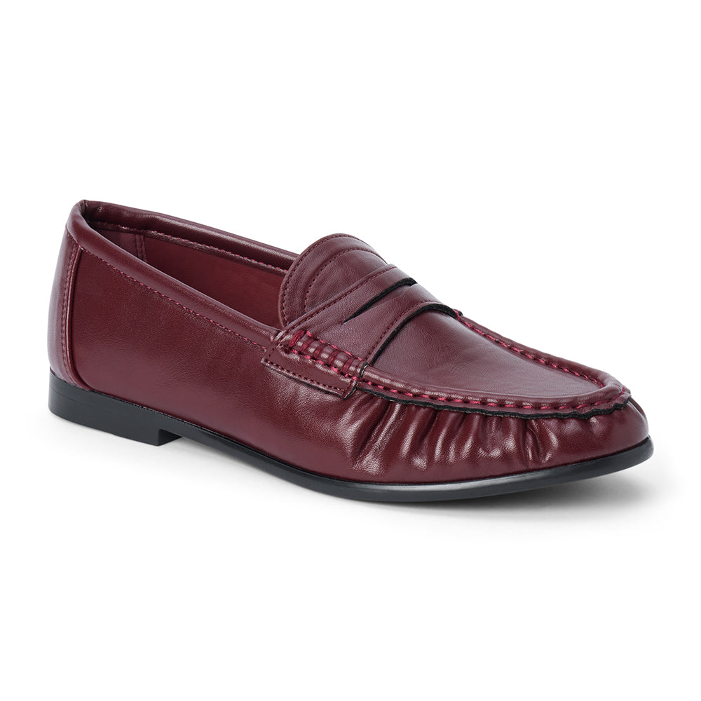 Vegan burgundy faux leather penny loafer with a penny strap, moc-toe stitching, gathered toe detail, and black low heel shown on a white background.