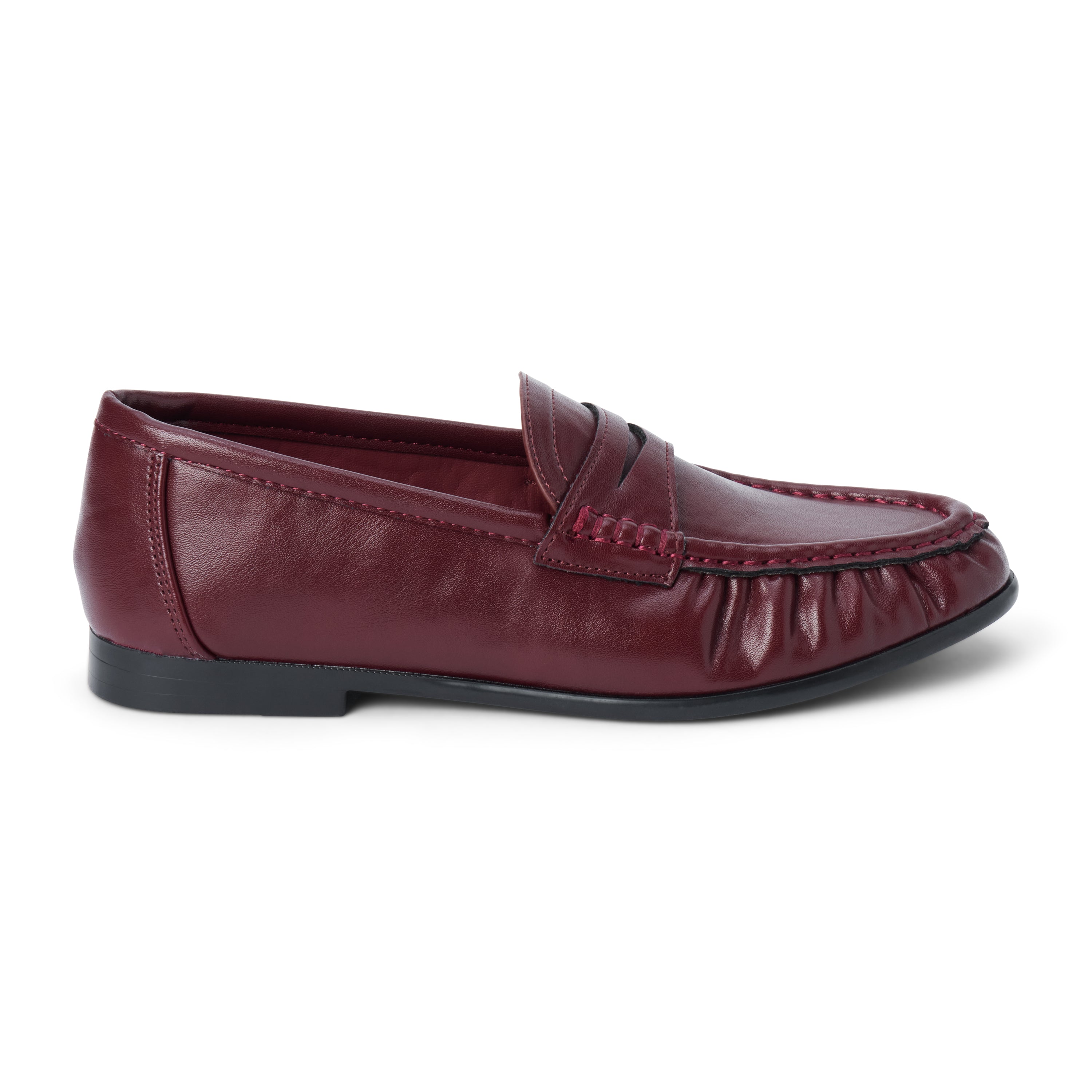 Vegan burgundy faux leather penny loafer with a penny strap, moc-toe stitching, gathered toe detail, and black low heel shown on a white background.