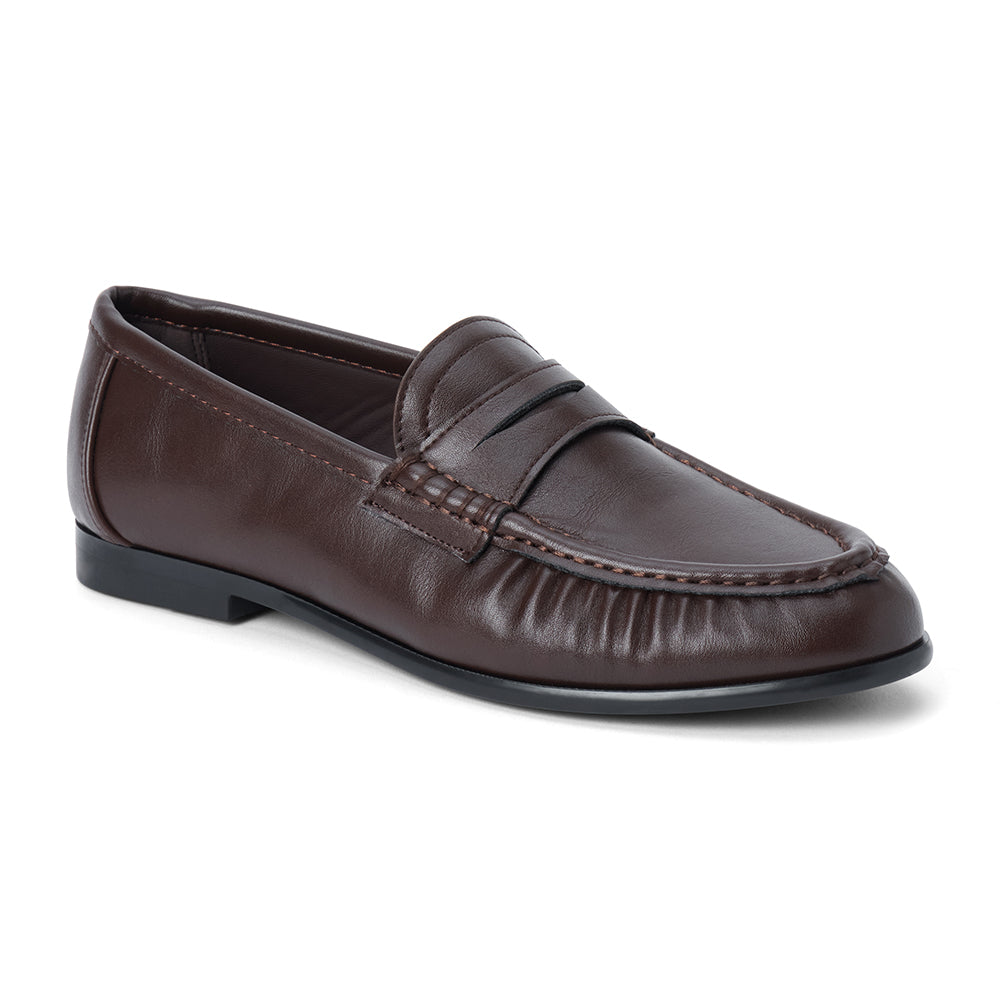 Vegan brown faux leather penny loafer with a penny strap, moc-toe stitching, gathered toe detail, and black low heel shown on a white background.