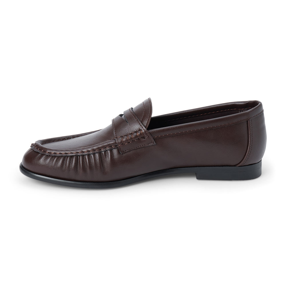 Vegan brown faux leather penny loafer with a penny strap, moc-toe stitching, gathered toe detail, and black low heel shown on a white background.