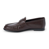 Vegan brown faux leather penny loafer with a penny strap, moc-toe stitching, gathered toe detail, and black low heel shown on a white background.