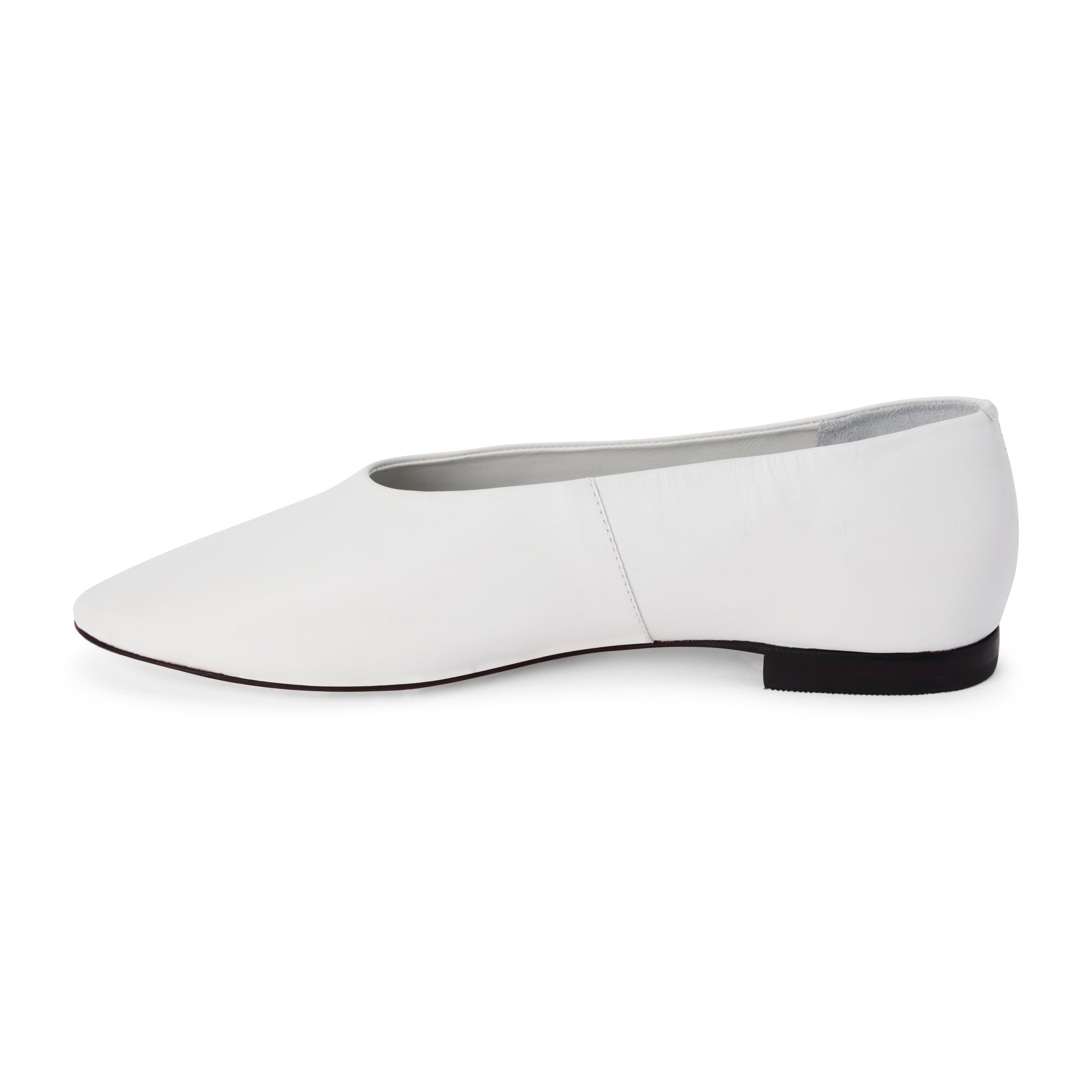 White leather flat with a softly squared toe, high-cut vamp, smooth upper, and low black heel shown on a white background.