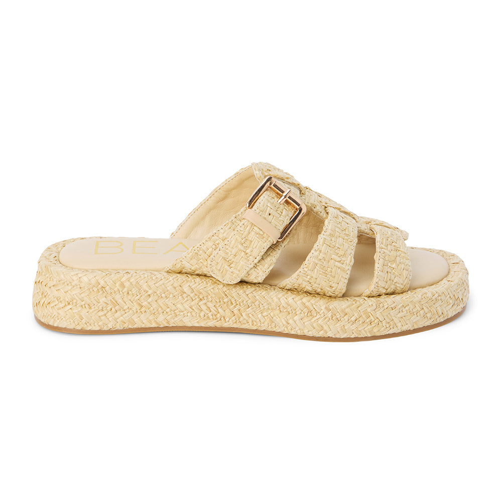 Natural raffia platform slide sandals with woven straps and an adjustable buckle detail. A breezy, laid-back style perfect for warm-weather wear.