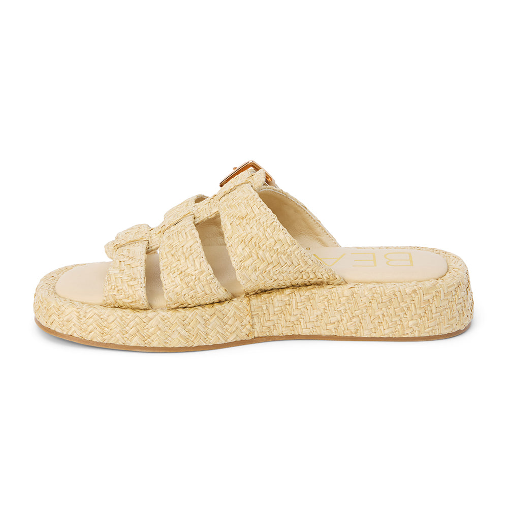 Natural raffia platform slide sandals with woven straps and an adjustable buckle detail. A breezy, laid-back style perfect for warm-weather wear.