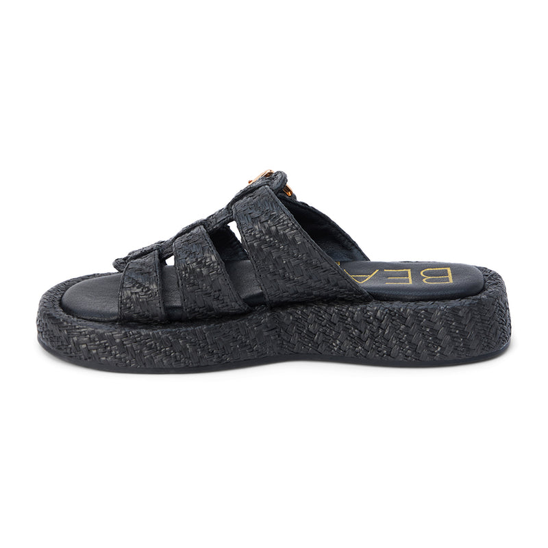 Black raffia platform slide sandals with woven straps and an adjustable buckle detail. A breezy, laid-back style perfect for warm-weather wear.