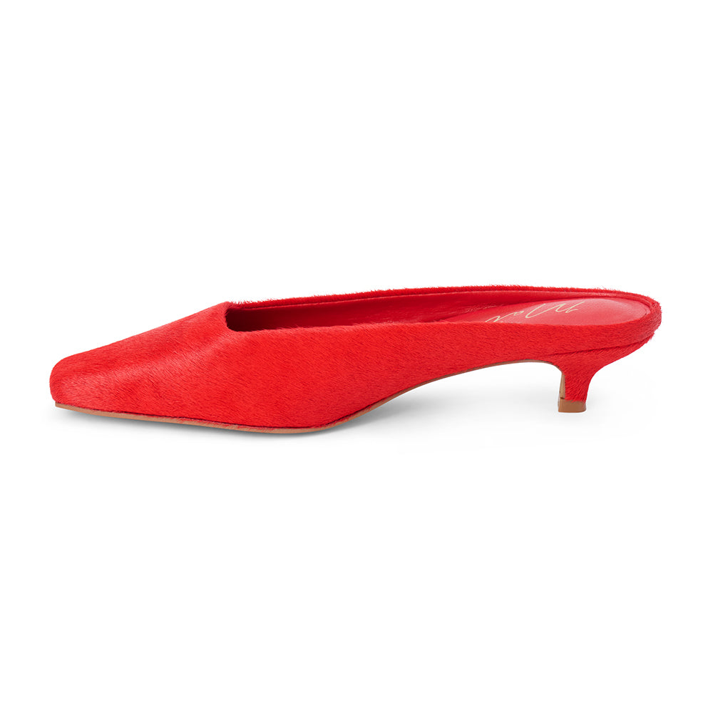 Red cow hair heeled mule with a pointed toe and low kitten heel shown on a white background.