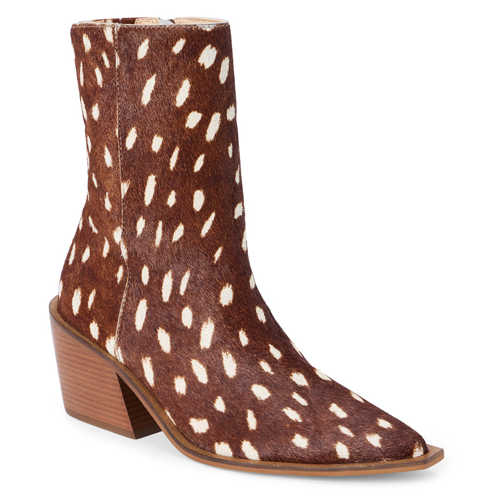 Brown and ivory spotted cow hair ankle boot with a pointed toe and angled block heel shown on a white background.