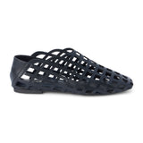Black woven leather flat with a cage-style upper, almond toe, low profile sole, and closed heel, shown in side profile on a white background.