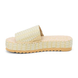 Green and ivory platform slide sandal with woven vegan raffia upper and thick sole, shown on a white background.