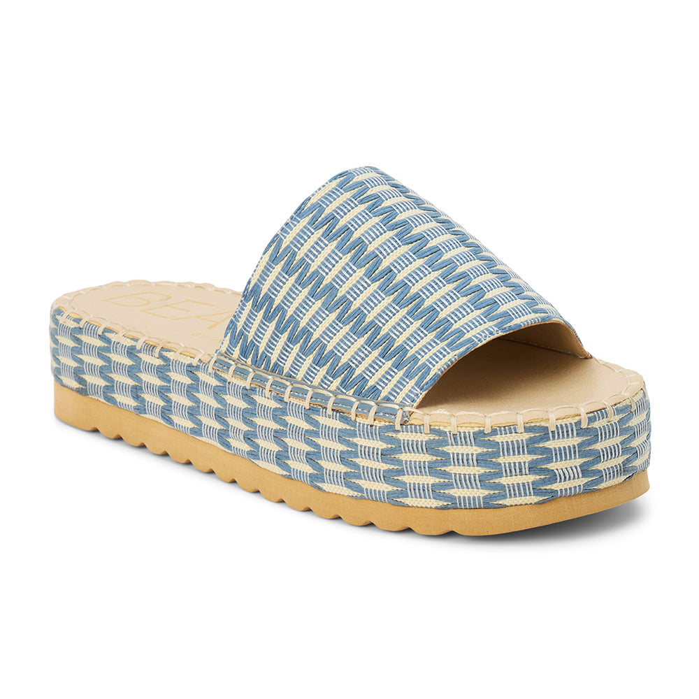 Blue and ivory platform slide sandal with woven vegan raffia upper and thick sole, shown on a white background.