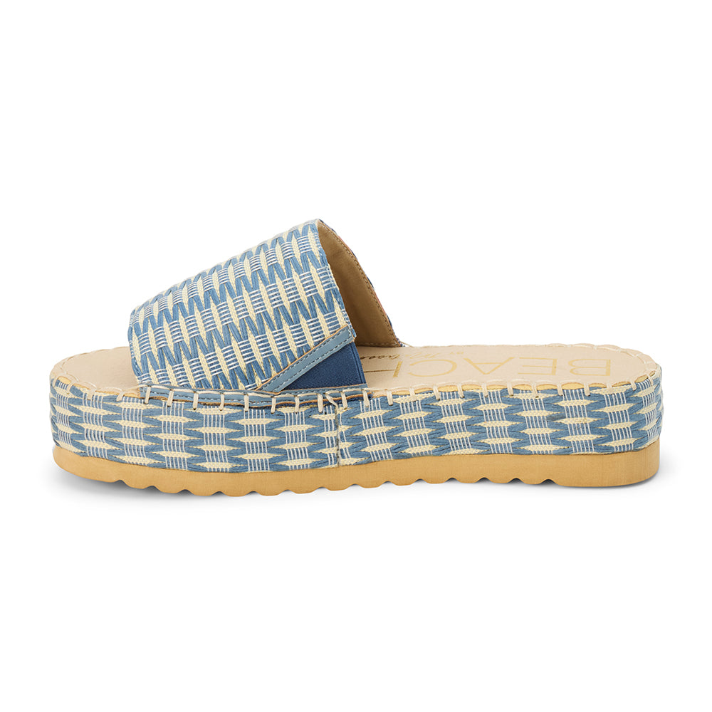 Blue and ivory platform slide sandal with woven vegan raffia upper and thick sole, shown on a white background.