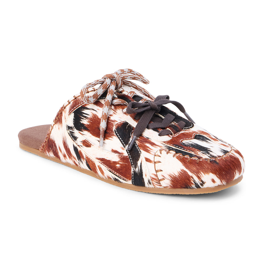 Brown and white cow hair mule with a lace-up front, stitched detailing, flat sole, and open back, shown in side profile on a white background.