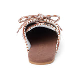 Brown and white cow hair mule with a lace-up front, stitched detailing, flat sole, and open back, shown in side profile on a white background.