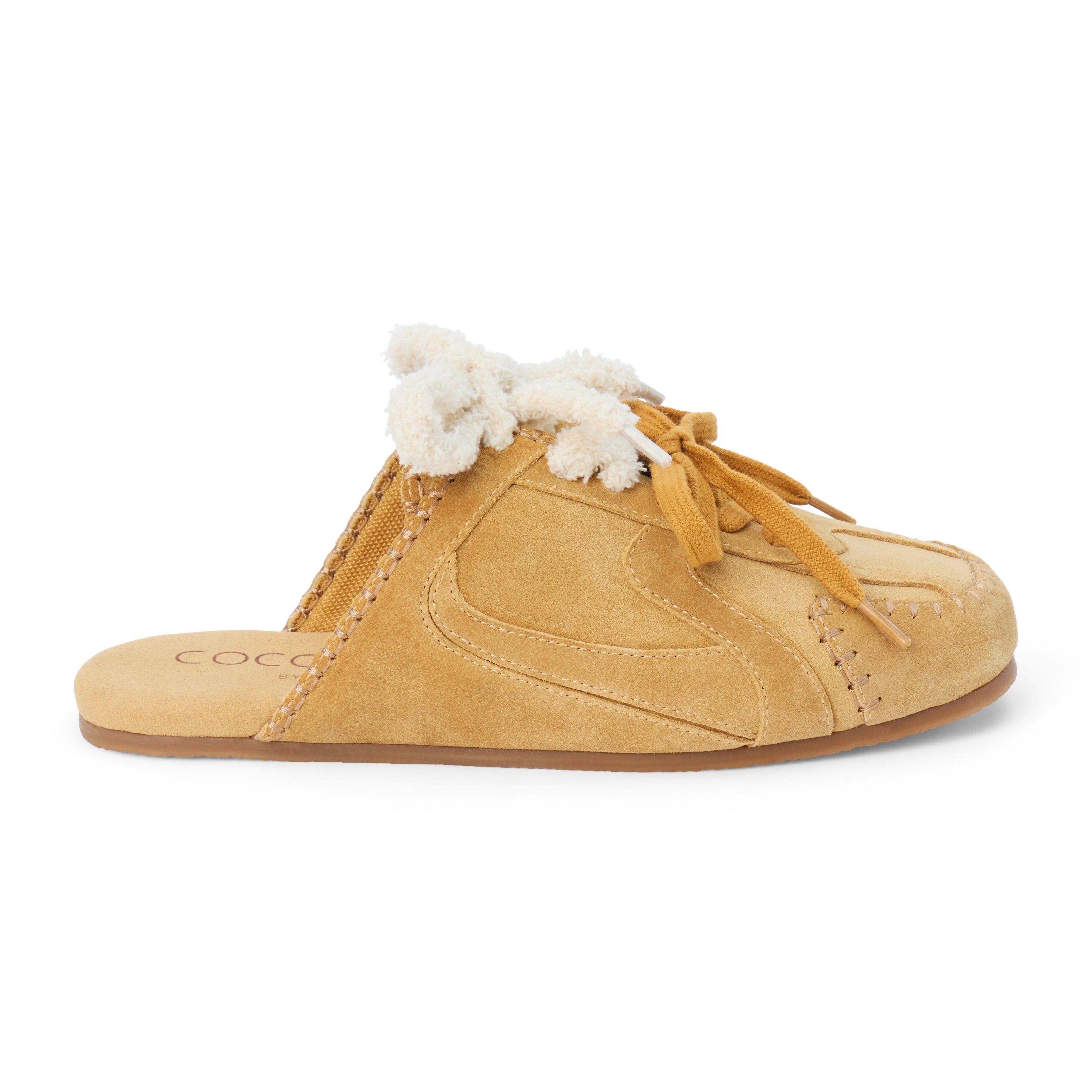 Tan suede sneaker mule with ivory shearling trim, tan laces, stitched detailing, and a flat sole shown on a white background.