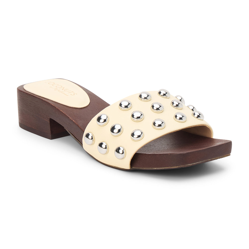 Light yellow vegan slide sandal with silver stud accents and low block heel, shown on a white background.