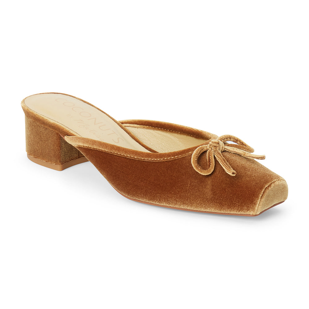 Vegan tan velvet heeled mule with a square toe, tonal bow detail, open back, and low block heel shown on a white background.