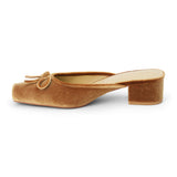 Vegan tan velvet heeled mule with a square toe, tonal bow detail, open back, and low block heel shown on a white background.