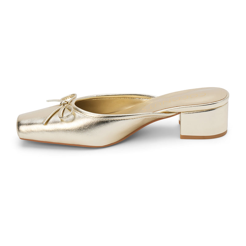 Geneva Heeled Mule – Coconuts by Matisse – Gold colored mule with a square toe, low block heel, and delicate bow detail.
